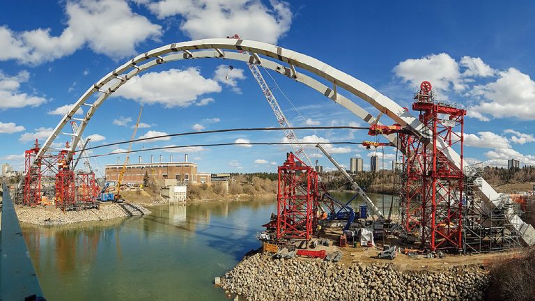 Edmonton’s Walterdale Bridge features a 230-metre deck fully spanning the North Saskatchewan River. The bridge is a structural steel arch with two 56-metre-high arches. Construction of the $155-million bridge has been controversial as the City of Edmonton has not revealed how much it will collect of the $11 million in late payment fees specified in the contract.