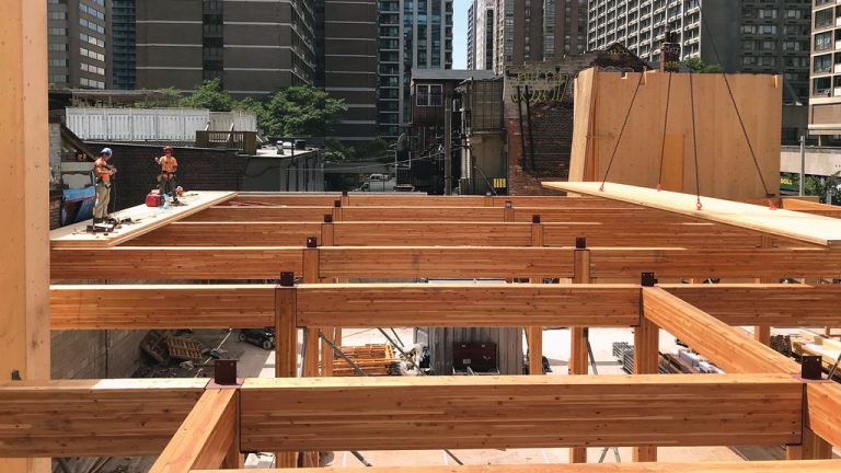 Four levels of glulam post-and-beam framing (shown above) spring from the basement level of a project to support typically 162-millimetre-thick, cross-laminated timber floor and roof panels. The multi-storey project, underway at Yonge and Charles streets in downtown Toronto, incorporates a heritage-listed building.