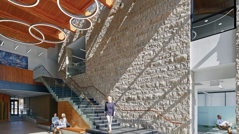 An exposed roof structure and wood veneer panels are juxtaposed against a two-storey limestone wall in the North Bay Parry Sound District Health Unit in North Bay, Ont. The project was the recipient of the Northern Ontario Excellence Award in the 2018 Ontario Wood WORKS! wood design awards program.