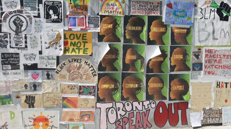 Posters of anti-racism messages line the hoarding around the Michael Garron Hospital construction site. The community came together to post the messages after nooses were found at several construction sites around Toronto, including two projects being constructed by EllisDon.