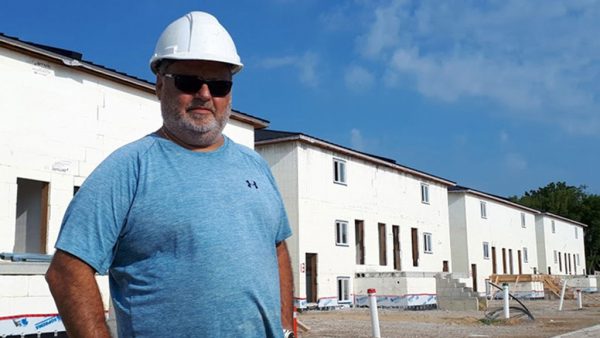 Jim Liovas, president of Liovas Homes, stands in front of a row of new migrant worker apartment blocks in Leamington, Ont. Each two-storey building, on either side of the street, will have six apartments and accommodate 36 workers.