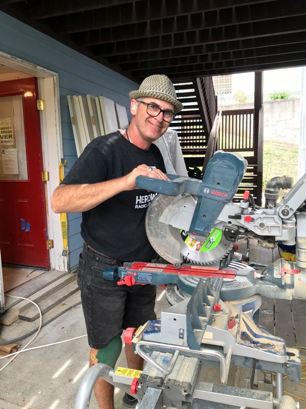 A volunteer operates a saw at a HeroWork renovation site.