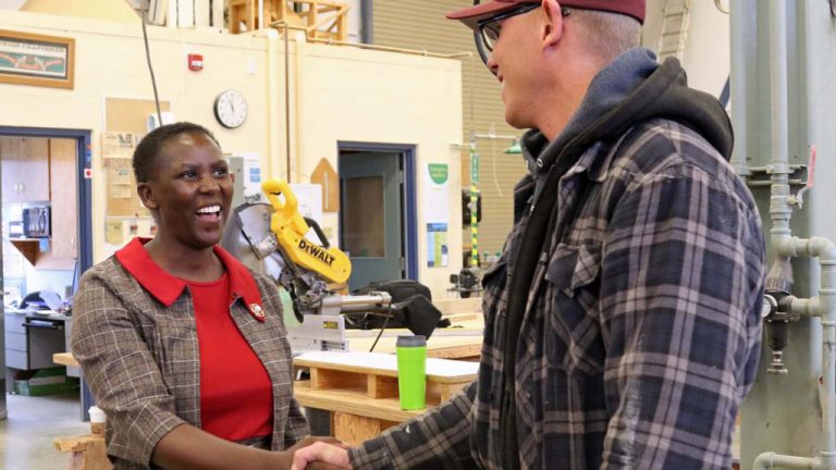 Beatrice Nyariki, registrar for Kisii National Polytechnic in Kenya, shakes hands with a Vancouver Island University carpentry student during a campus visit.