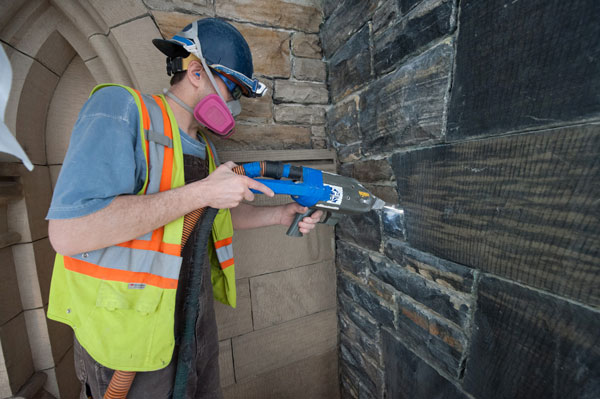 Machines are wheeled in that provide the power to handheld laser wands which are then pointed at the surface. The operator guides the laser, which appears as a small ring of light, and directs it across the stone surface removing the pollutant soot and other contaminants.