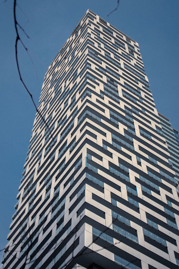 The tower on the Yonge + Rich Condo features a perforated white metal cladding which differentiates it from other towers in downtown Toronto. The building by Great Gulf was designed by architectsalliance.