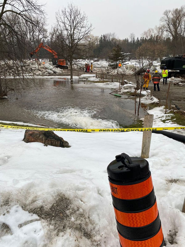 An excavator tries to clear up large chunks of ice that have formed along the Credit River in the community of Churchville in Brampton, Ont. after extensive flooding occurred.