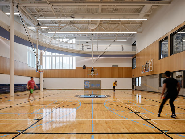 The upper levels of the building are focused on athletics and include a gym, a fitness centre and a brightly coloured, multi-level floating running track which encircles the building. The track was designed to create open access, and both visually and physically connects to nearby basketball, yoga and fitness studios.