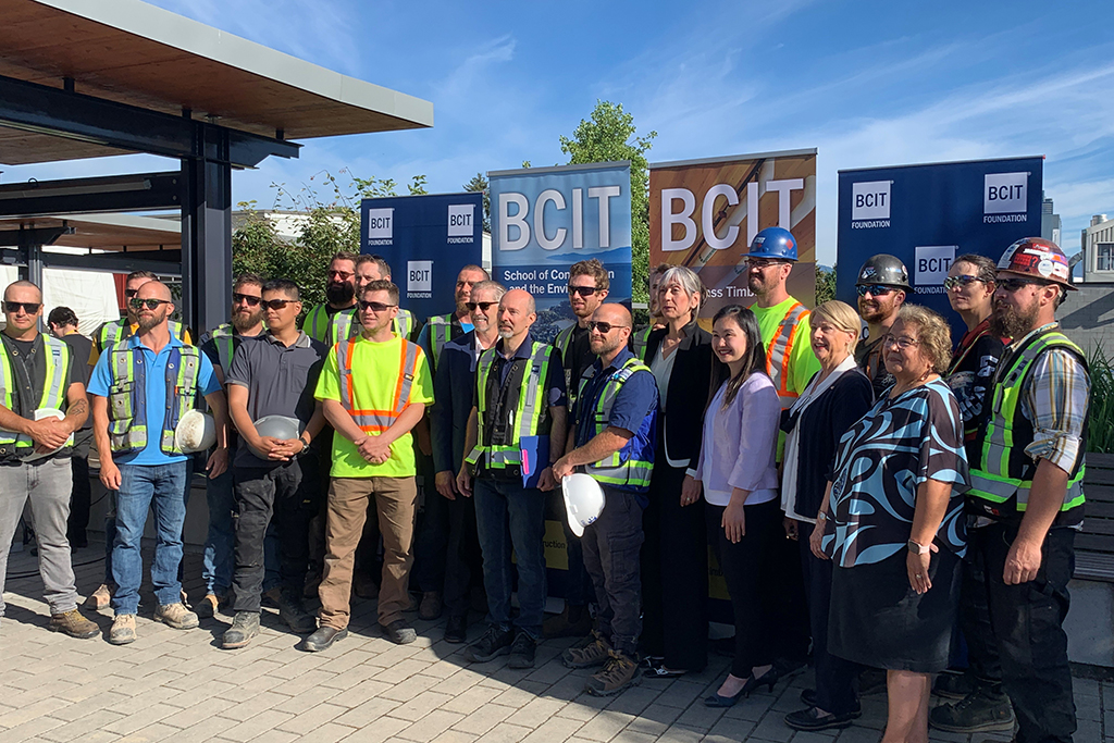 BCIT School of 鶹ýion and the Environment dean Wayne Hand (middle, in sunglasses) poses with students and dignitaries at the Applied Mass Timber Build Open House on Aug. 15 at BCIT’s Burnaby campus.