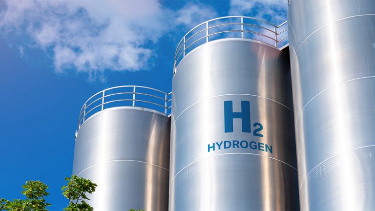 Three large metal silos and one is labelled H2 and the word hydrogen.