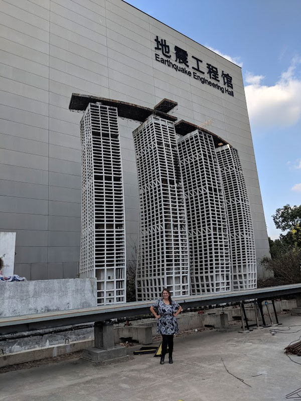 Dr. Lisa Tobber stands in front of the broken specimen of a scaled down highrise building at the earthquake engineering facility at Tongji University in Beijing.