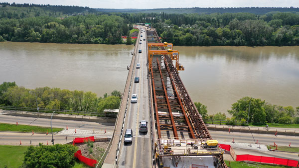 The two gantry cranes used by Graham Construction travel along the Groat Road bridge’s superstructure to move heavy sections of the bridge. The gantries ran along a temporary I beam on the bridge and trusses attached to the outside of the bridge to circumvent issues surrounding river access.
