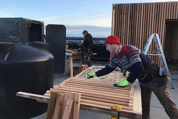 Carpenters Craig McWilliam, rear, and Bjorn Rieder, front, working on the upper level of the seaworthy sauna project HAVN in Victoria.