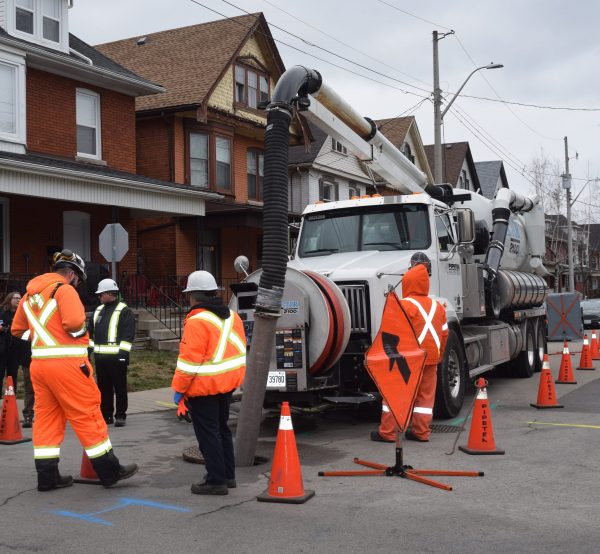 The City of Hamilton handed out notices of a cross-connected sewer line to homeowners in east Hamilton Jan 10 as crews used a vacuum truck to remove sewage.