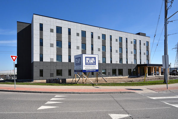 The four-storey, 22,000-square-foot YW Kitchener-Waterloo is a multi-unit residential building that was built under the Rapid Housing Initiative. The 41-unit building, which was built using modular construction, features timber framing and cross-laminated timber.