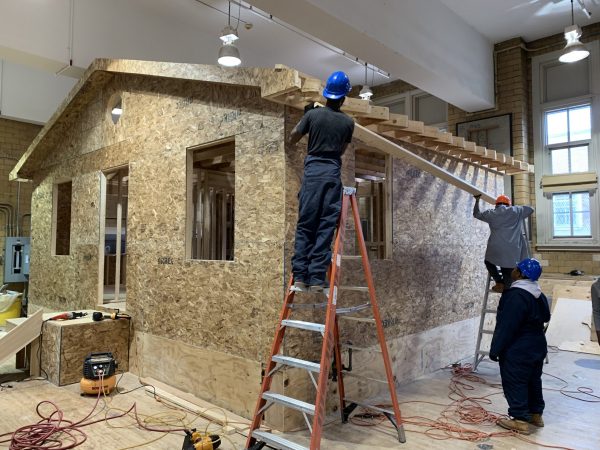 Pictured is a house being built by trade school high school students. Every year students at an inner-city high school in the south Bronx build a full-sized house in the school’s former gymnasium. It is part of the curriculum at the Bronx Design and Construction Academy.