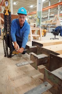 Mass timber course instructor Jason Moreau examines metal knife-edge plate for mass timber column.