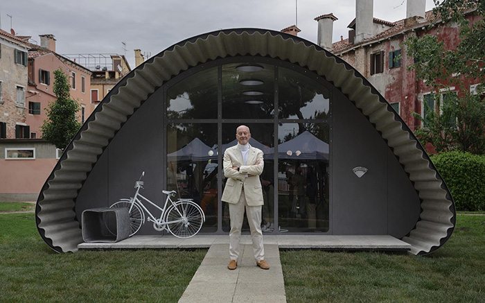 Norman Foster stands outside the Essential Homes rollable concrete structure in Venice.