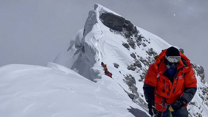 Mike Enter climbs along a steep ridge in the Himalayas on his way to reach the summit of Mount Everest.