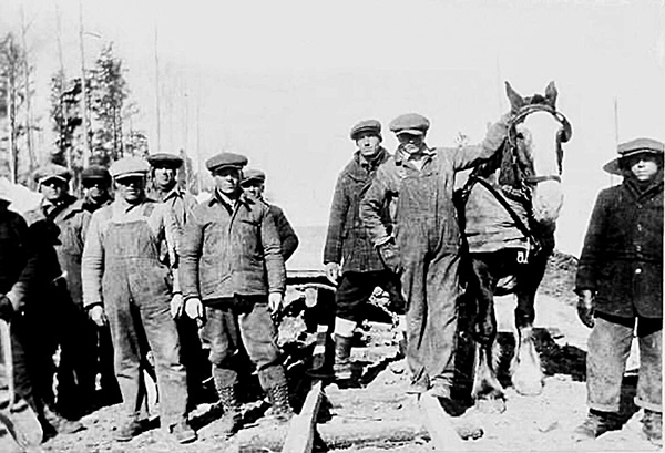 Workers from camp C9, just outside of Upsale, west of Port Arthur/Fort William, at work on the Trans-Canada Highway. Each camp had about 130 workers. Wooden rail systems, shown here, made it easier for horses to haul fill.