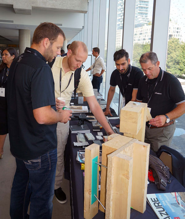 Rothoblaas exhibitors illustrate connectors to customers during the Mass Timber Seminar Conference at George Brown College in Toronto.