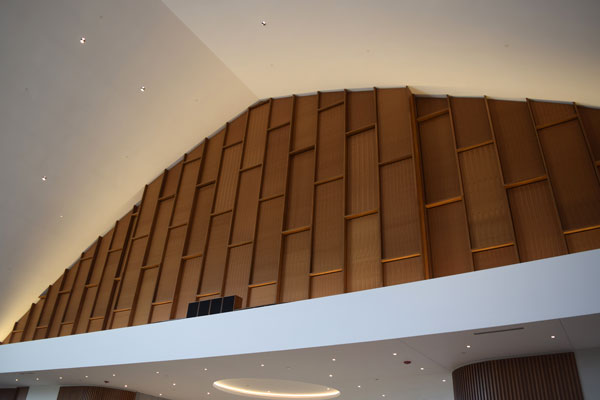 Acoustic wood ceiling and wall manufacturer Geometrik contributed this panel with micro perforations and cloth to enhance acoustics.