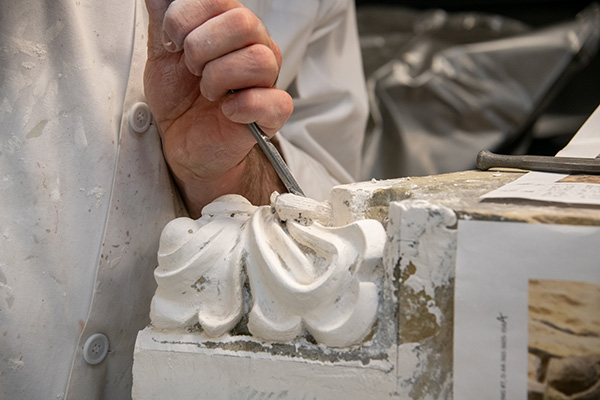 Danny Barber building up deteriorated sculptural elements in plaster on the existing stone. This will serve as a model to then carve in stone.