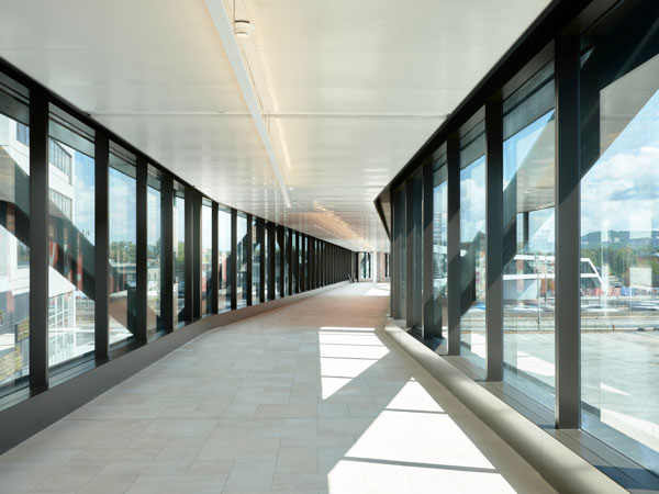 The pedestrian bridge over a major expressway carries pedestrians from the nearby metro station.