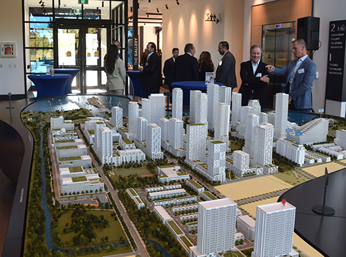 Gord Buck of Argo (far right) and Jim Ritchie of Tridel discuss architectural models of Lakeview Village during a ceremony marking groundbreaking of Tridel’s Harbourwalk residence in Mississauga.