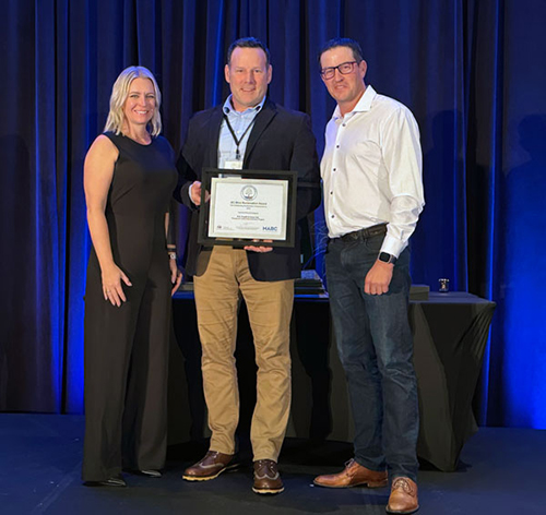 Linsey and Jamie Johannson, owners of R.E. Postill & Sons Ltd., and Tim Antill, manager and senior reclamation inspector with the BC Ministry of Energy, Mines and Low Carbon Innovation, stand with the award.