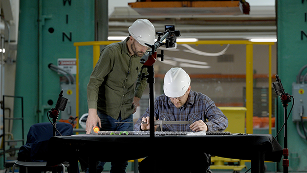 Engineers evaluate rebar samples before they are entered into a device that tests how they deform and break.