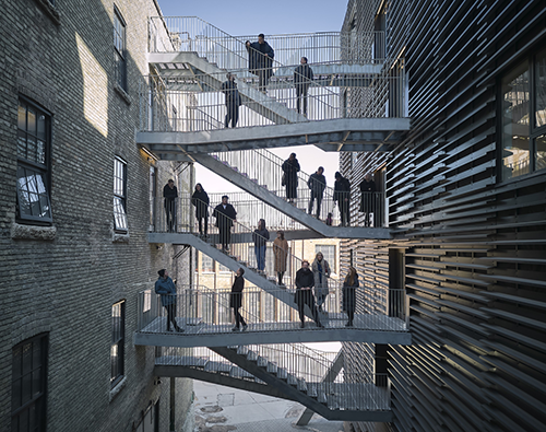 Pictured is the 5468796 team on the shared exit stair connecting the recently reimagined historic 90 and newly constructed 100 Alexander project in Manitoba.