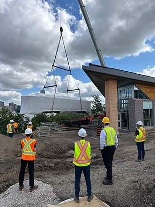 This photo shows the lowering of the wrapped streetcar on to temporary tacks, to be slid into the pavilion.