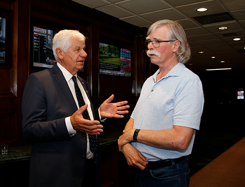 Former CFBA president Gary van Bolderen (left) visited with Mike Carter, executive di-rector of the London and District Construction Association, during COCA celebrations June 12.