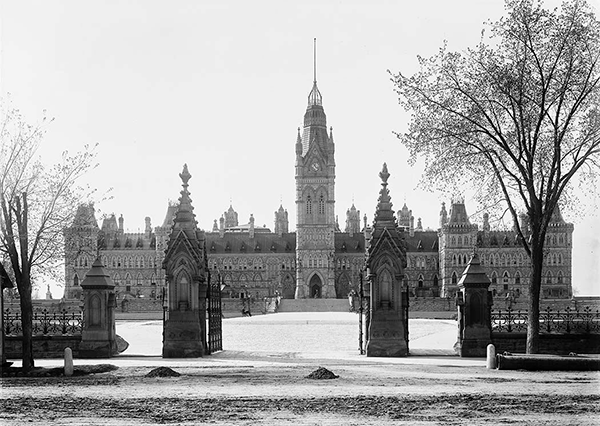 The wrought iron Queen’s Gates are one of Parliament Hill’s oldest features. Installed in 1876, they are shown in this archival image taken by Alexander W. Galbraith in 1900 in front of the original Parliament Building, which was destroyed in a 1916 fire.