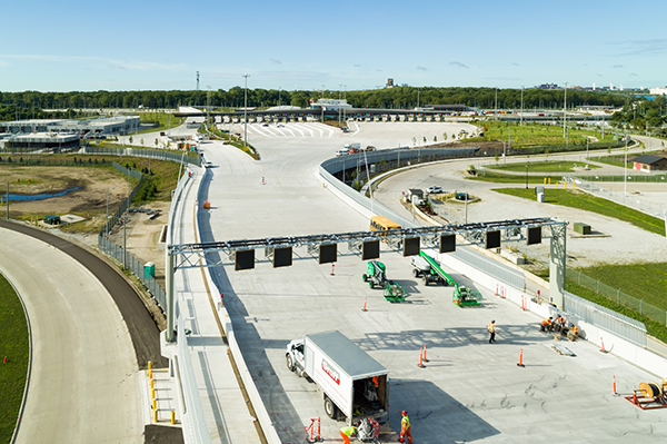 2. Shown is the Gordie Howe International Bridge's Canadian port of entry, with dynamic overhead traffic controls and cycling-pedestrian lanes at left.